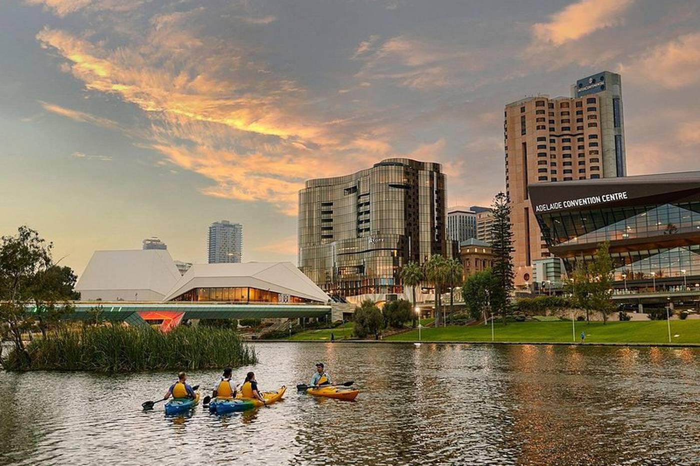 The Adelaide skyline across the River Torrens at dusk, kayakers on the water