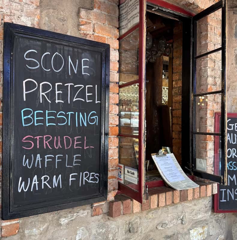 A bakery chalkboard offering scones, pretzels, beesting, strudel and waffles